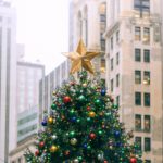 decorated christmas tree against urban multistage building facades